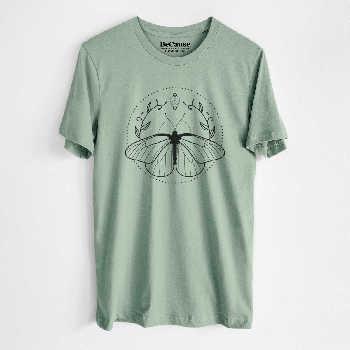 Sage green lightweight cotton t-shirt laid flat, printed with a black ink butterfly inside a circle, framed by moon phases and leaves.