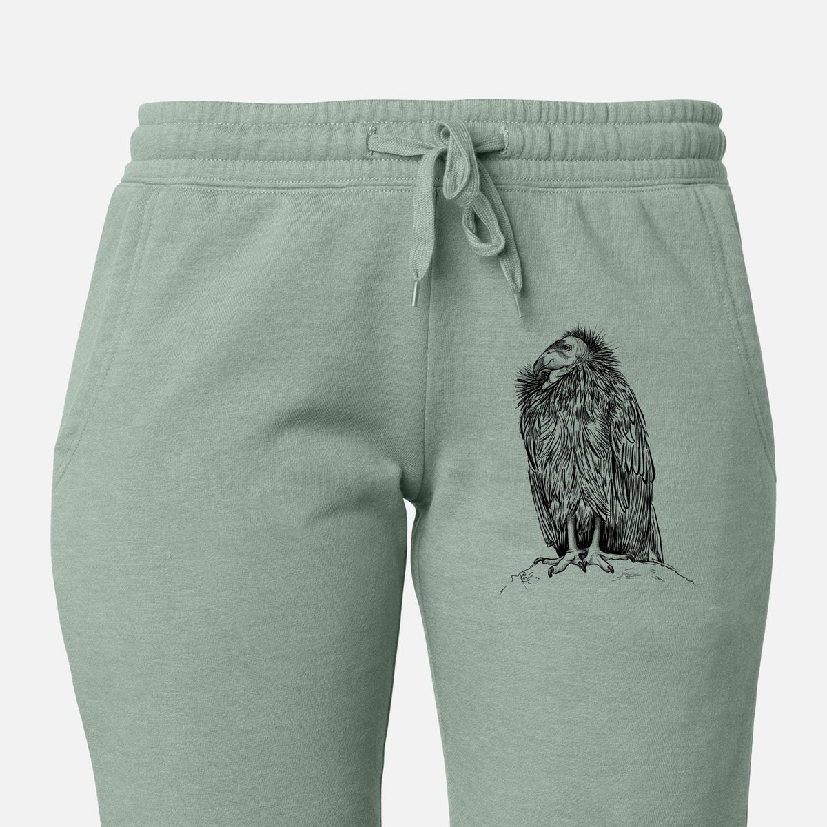 Front of sage green Cali Wave sweatpants, printed with a detailed black ink illustration of a California condor perched with folded wings on the leg.