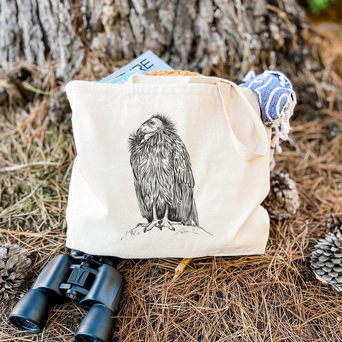 Canvas tote bag printed with a detailed black ink illustration of a California condor perched with folded wings, resting on dry grass beside a pair of binoculars.