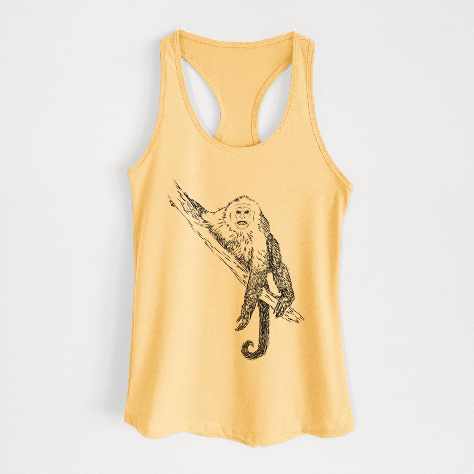 Banana cream women's racerback tank top laid flat, printed with a detailed black ink illustration of a capuchin monkey climbing a branch.