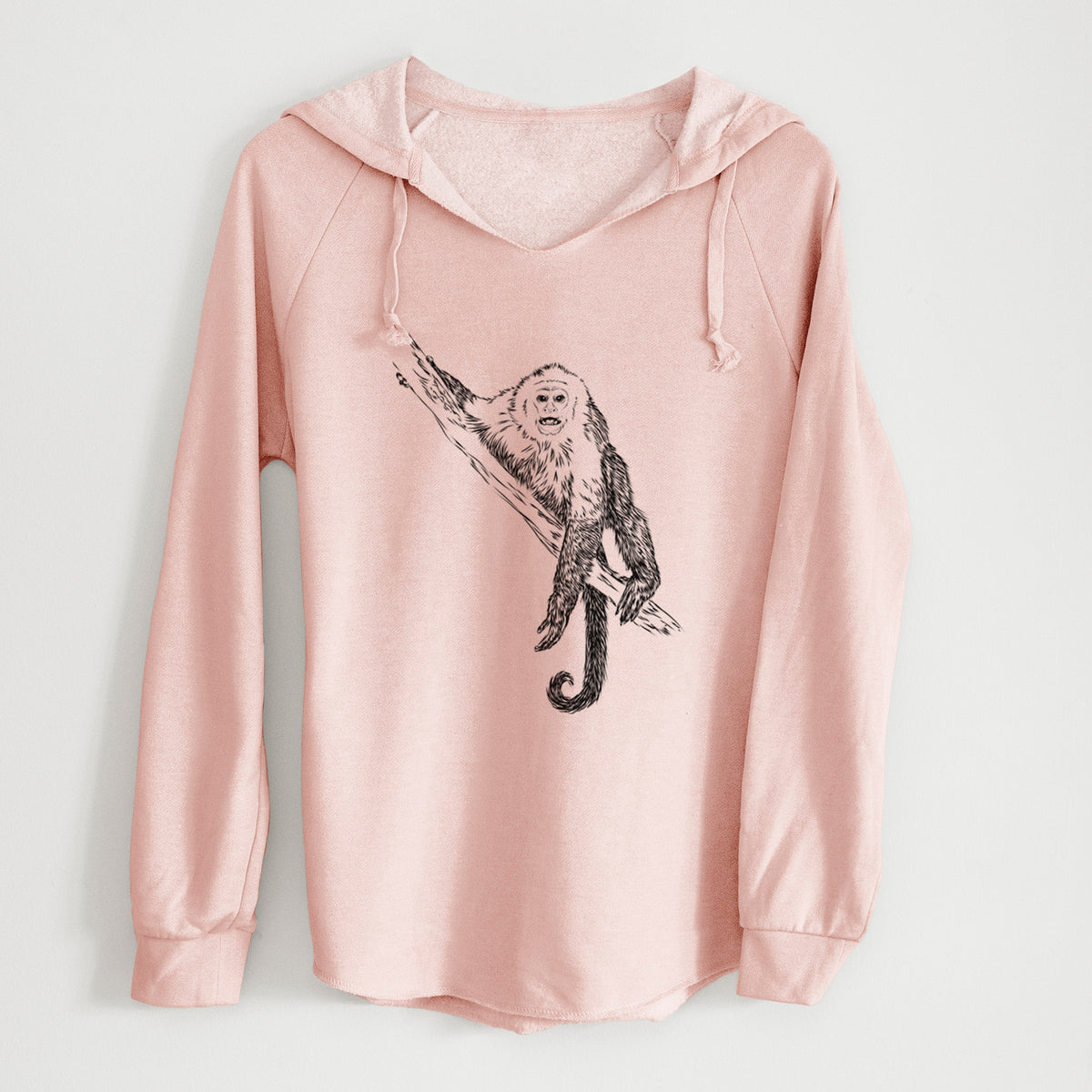Blush pink women's Cali Wave hooded sweatshirt laid flat, printed with a detailed black ink illustration of a capuchin monkey climbing a branch.