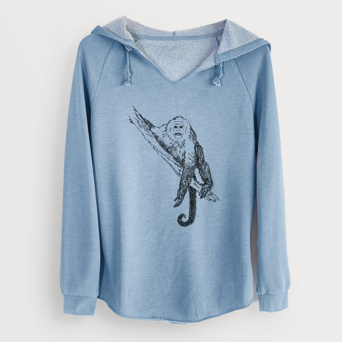 Misty blue women's Cali Wave hooded sweatshirt laid flat, printed with a detailed black ink illustration of a capuchin monkey climbing a branch.