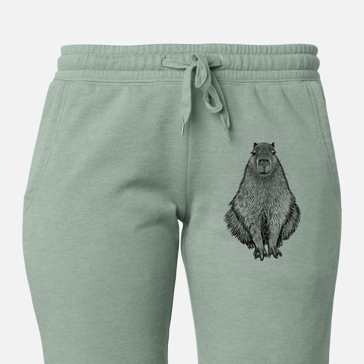 Front of sage green Cali Wave sweatpants, printed with a detailed black ink illustration of a capybara sitting and facing forward on the leg.