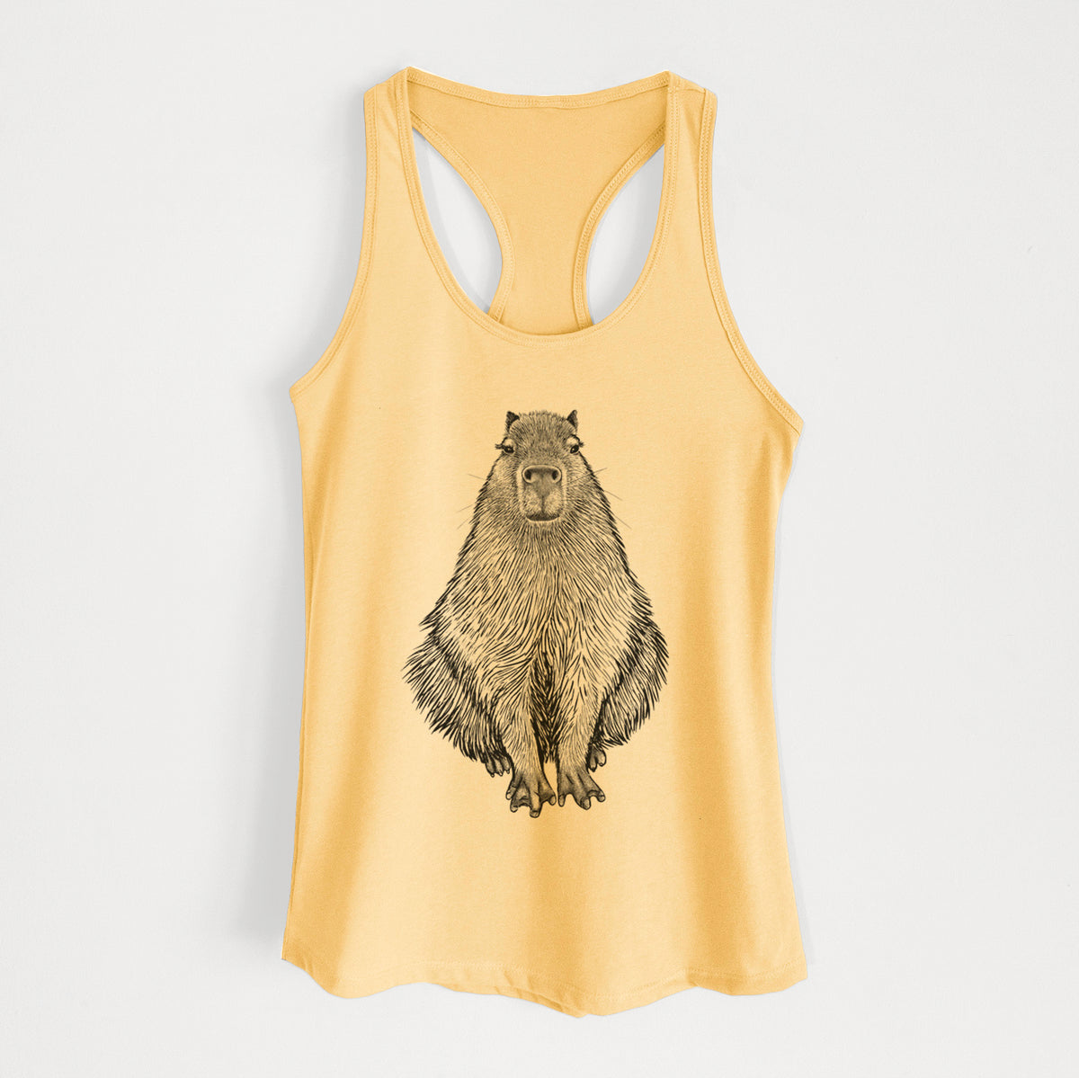 Banana cream women's racerback tank top laid flat, printed with a detailed black ink illustration of a capybara sitting and facing forward.