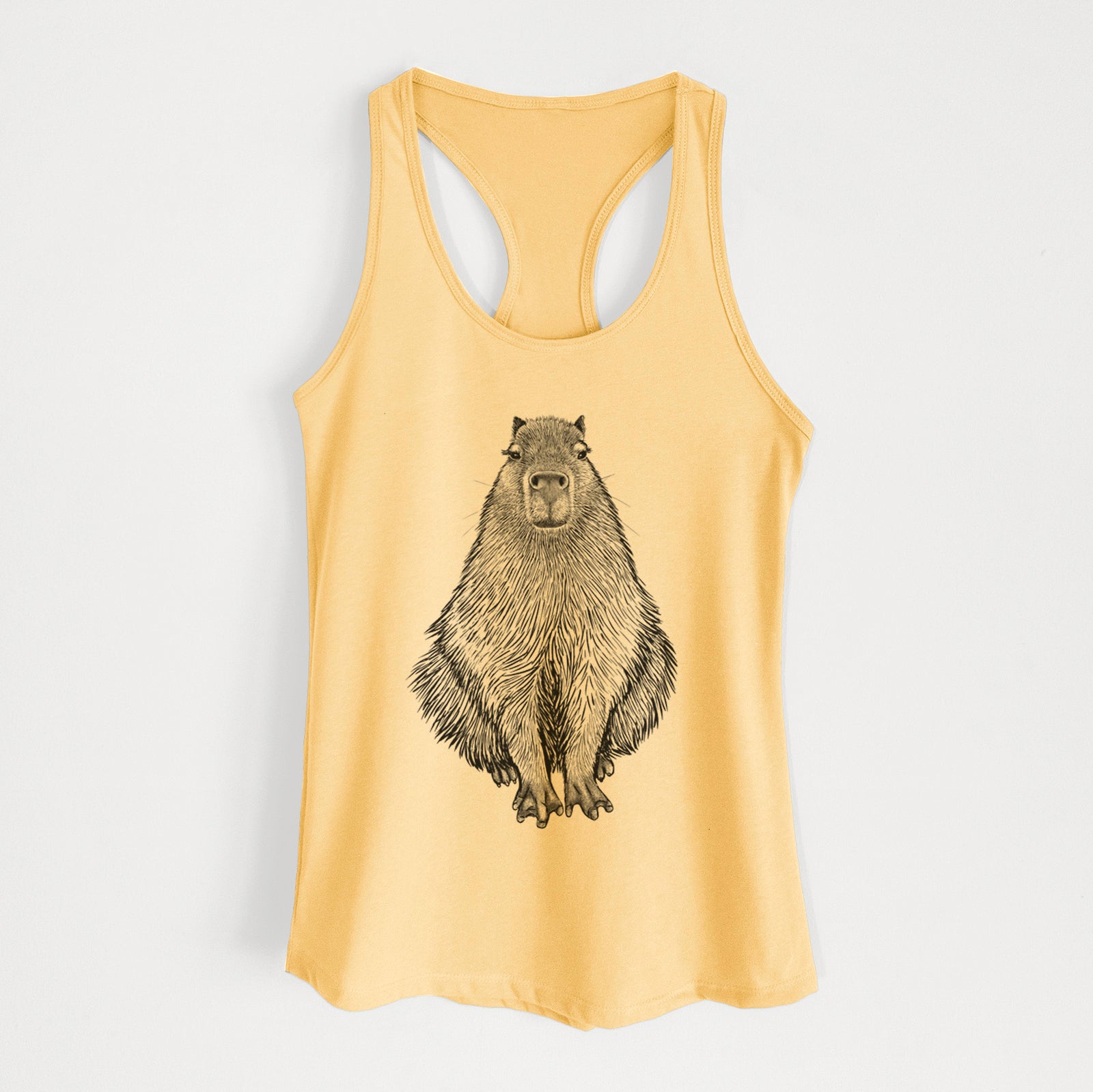 Banana cream women's racerback tank top laid flat, printed with a detailed black ink illustration of a capybara sitting and facing forward.