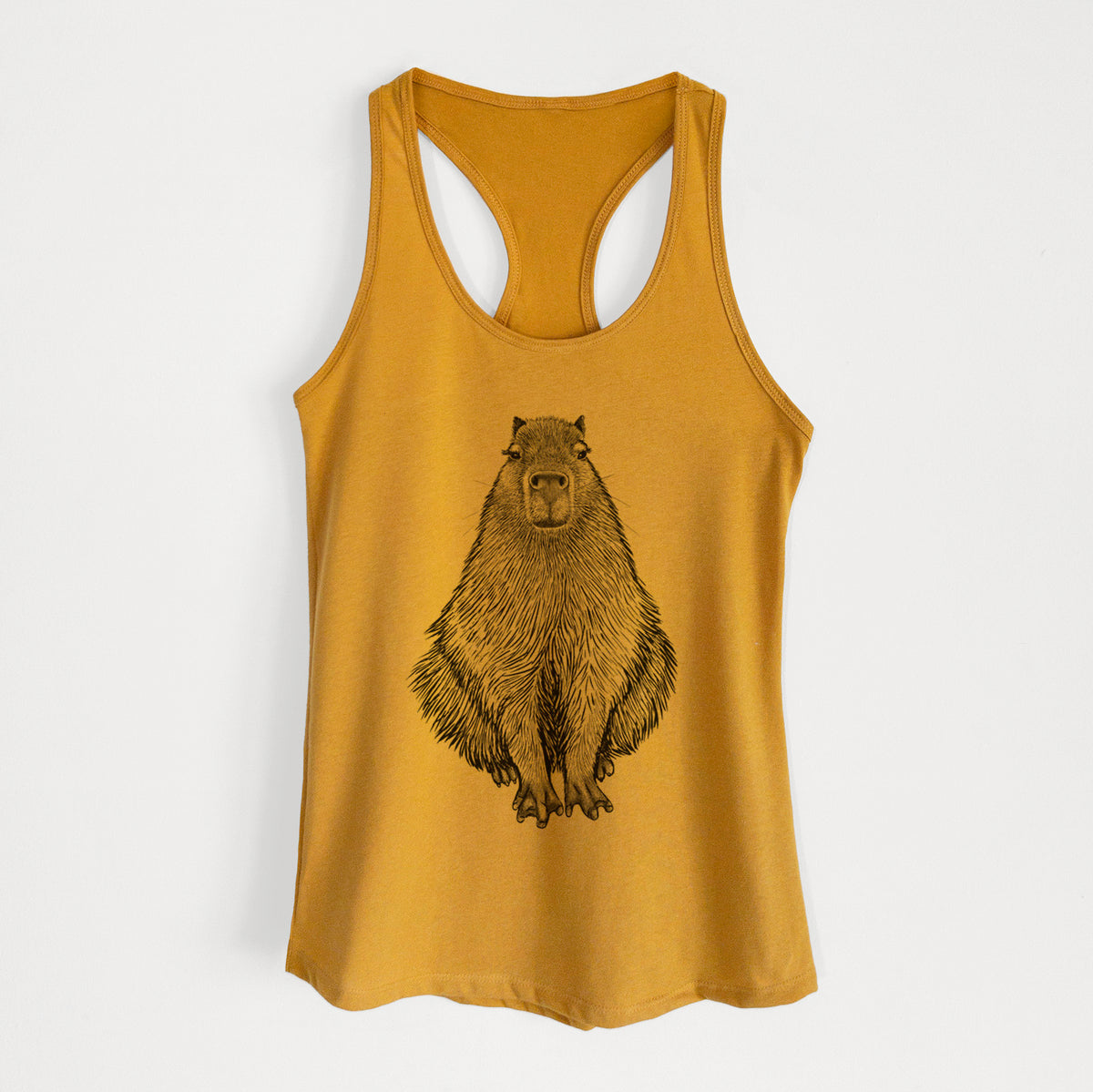 Gold women's racerback tank top laid flat, printed with a detailed black ink illustration of a capybara sitting and facing forward.
