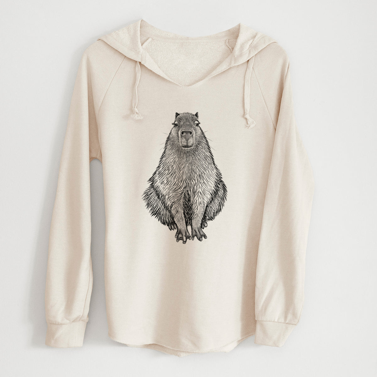 Bone cream women's Cali Wave hooded sweatshirt laid flat, printed with a detailed black ink illustration of a capybara sitting and facing forward.