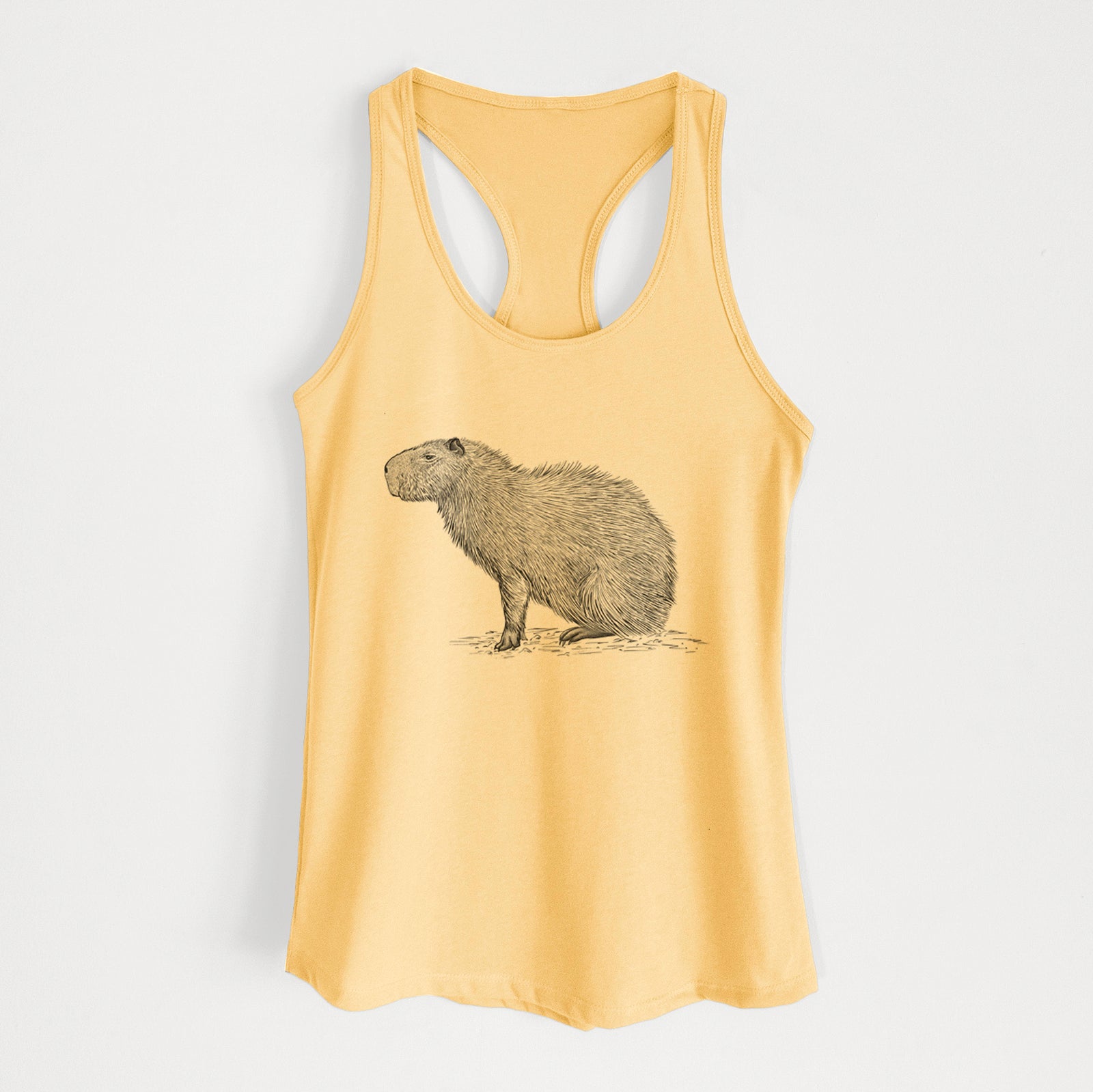 Banana cream women's racerback tank top laid flat, printed with a detailed black ink illustration of a capybara standing in profile.