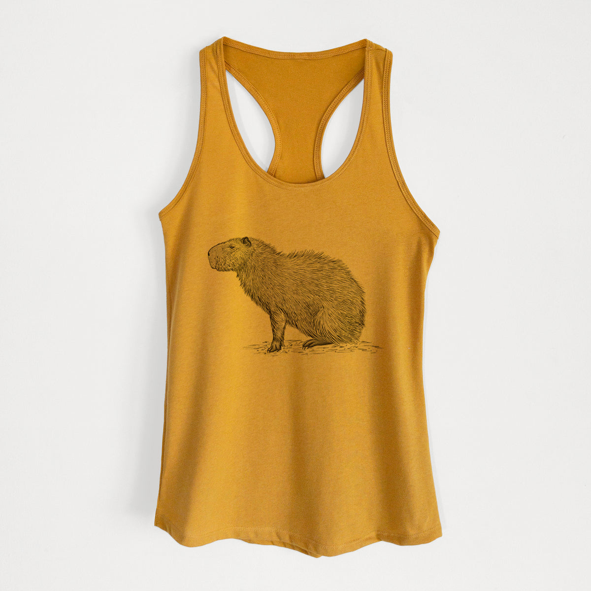 Gold women's racerback tank top laid flat, printed with a detailed black ink illustration of a capybara standing in profile.