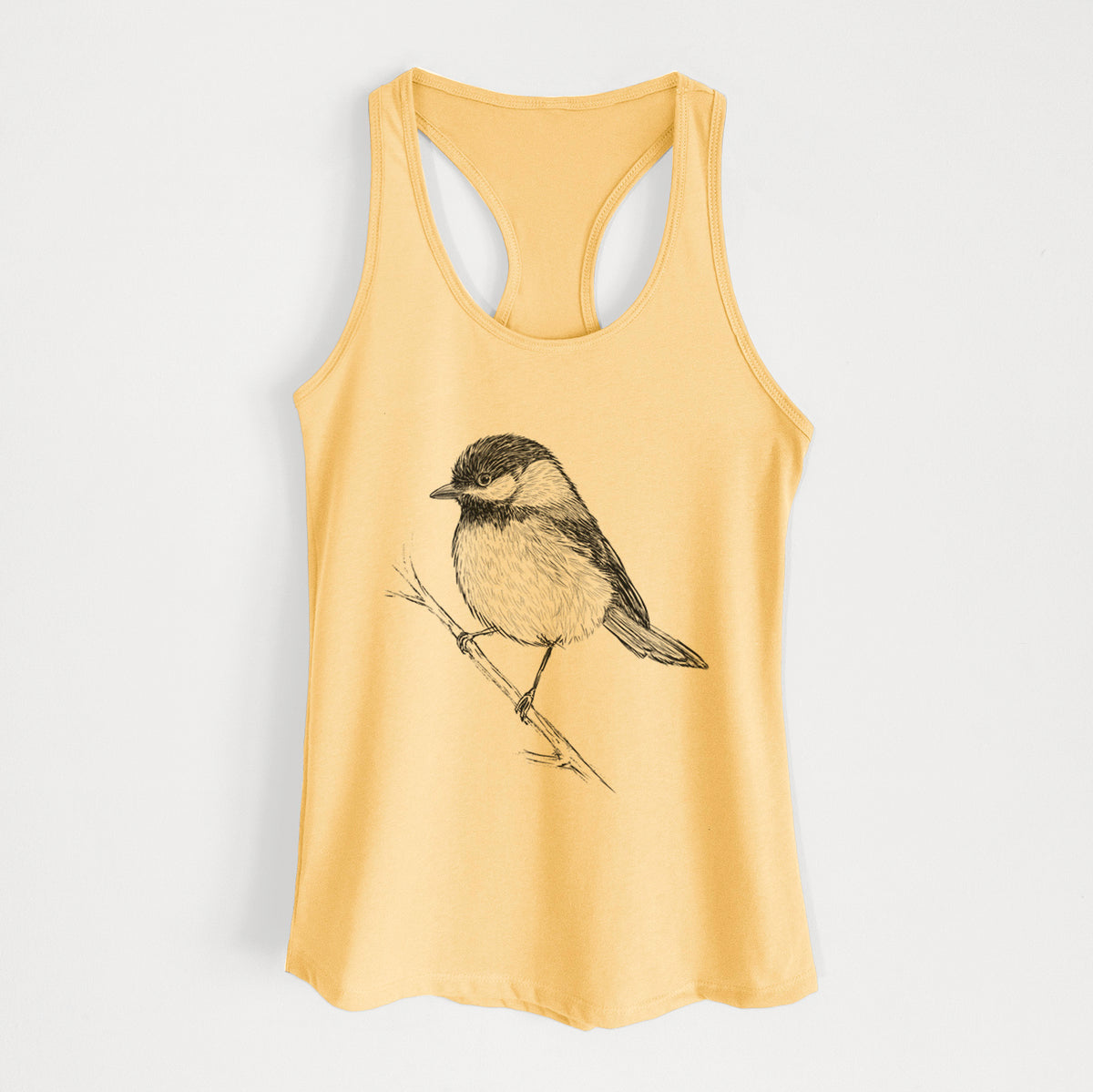 Banana cream women's racerback tank top laid flat, printed with a detailed black ink sketch of a black-capped chickadee perched on a branch.