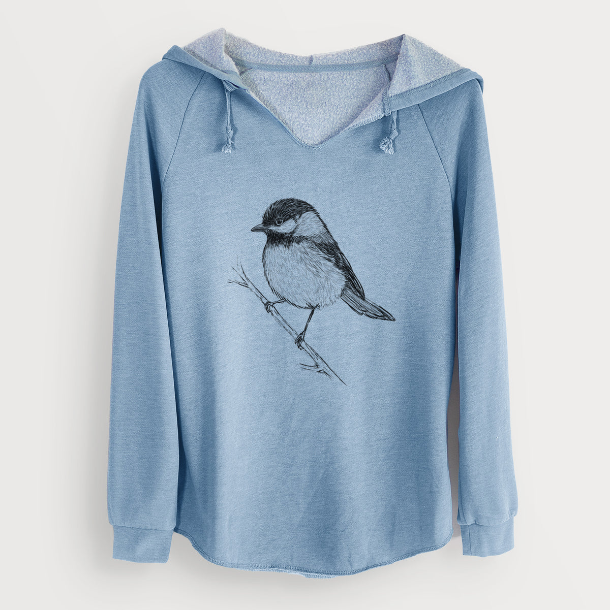 Misty blue women's Cali Wave hooded sweatshirt laid flat, printed with a detailed black ink sketch of a black-capped chickadee perched on a branch.