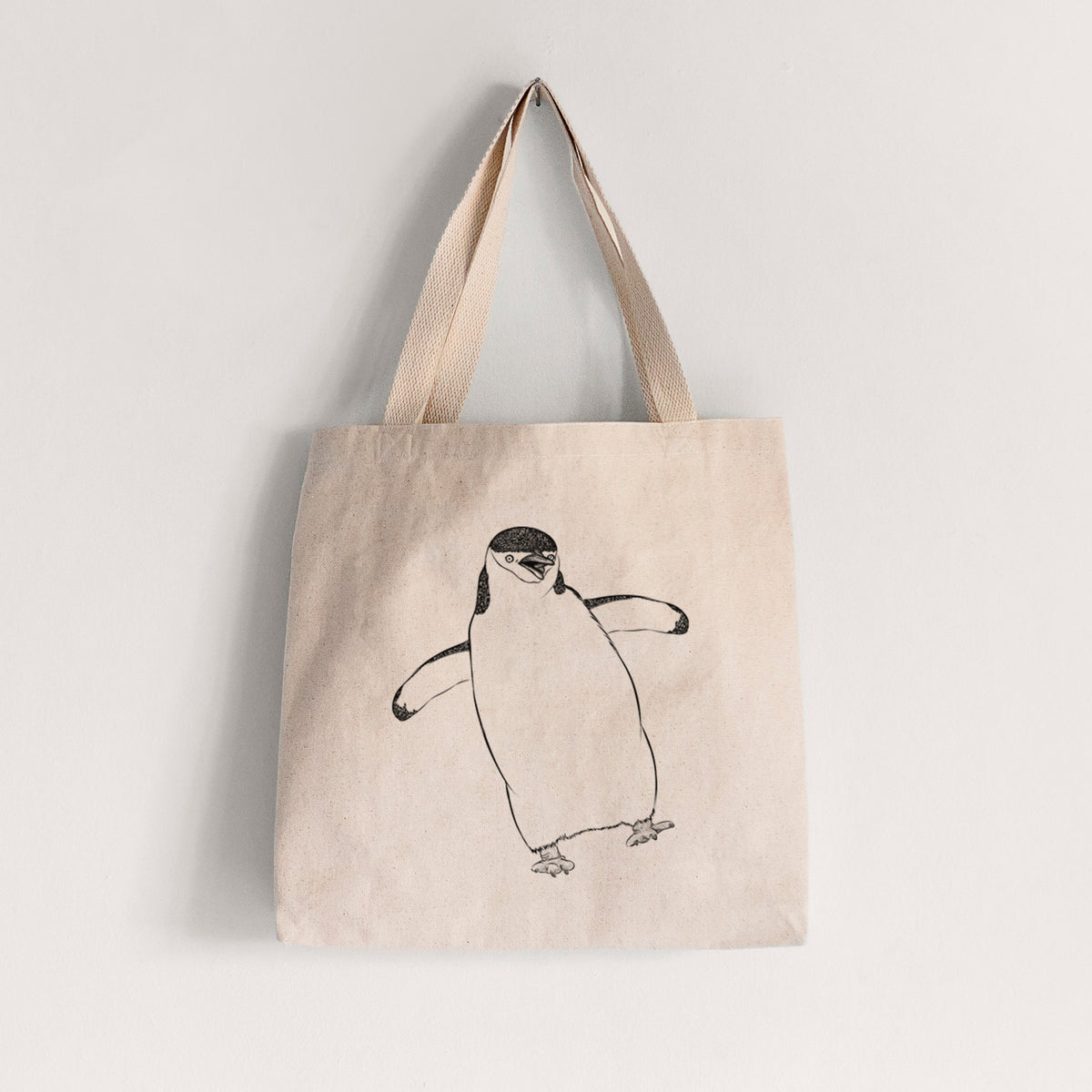Natural canvas tote bag printed with a black ink illustration of a chinstrap penguin standing with its flippers out.