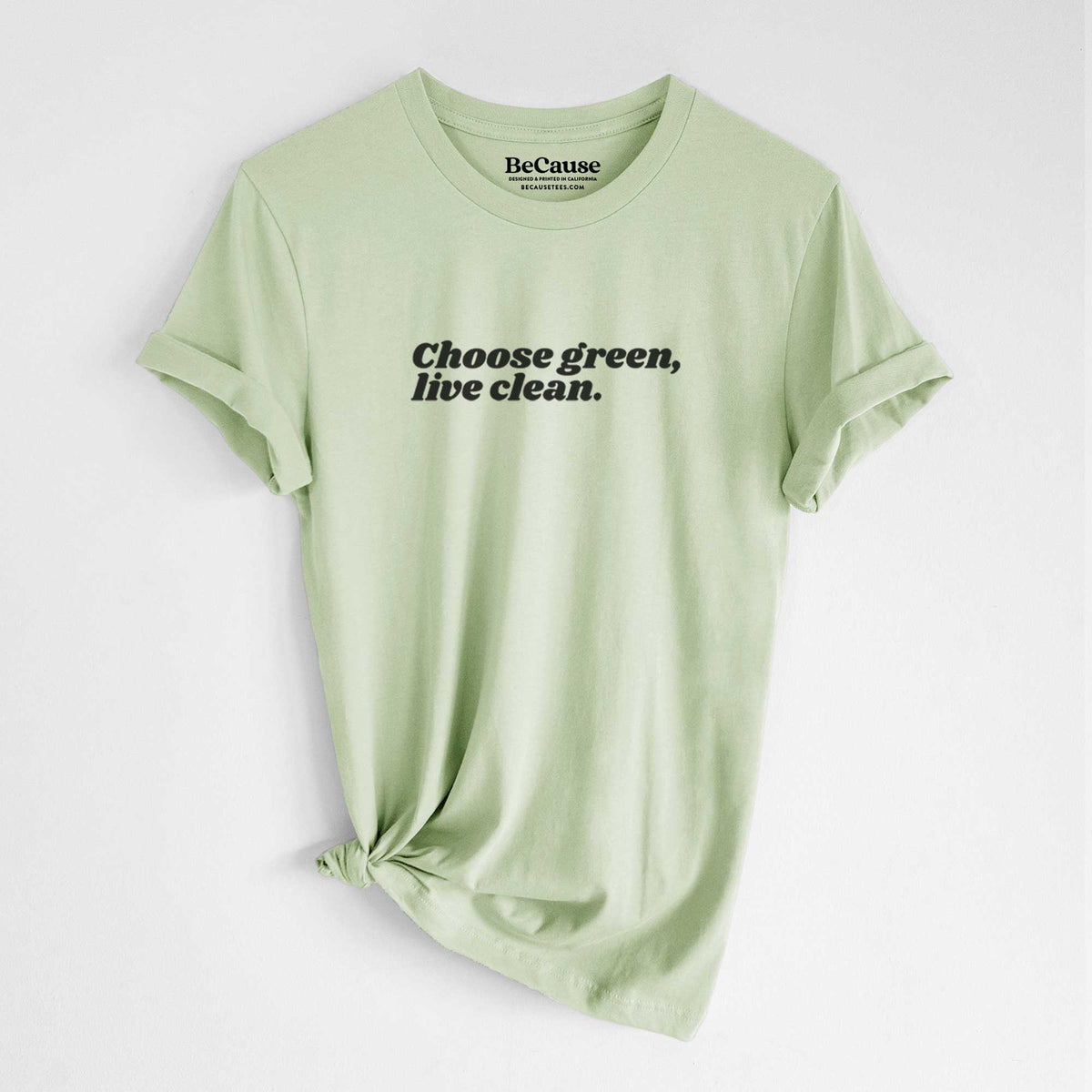 Spring green lightweight cotton t-shirt laid flat with the sleeves rolled, printed with small black script words reading Choose Green, Live Clean on the upper chest.