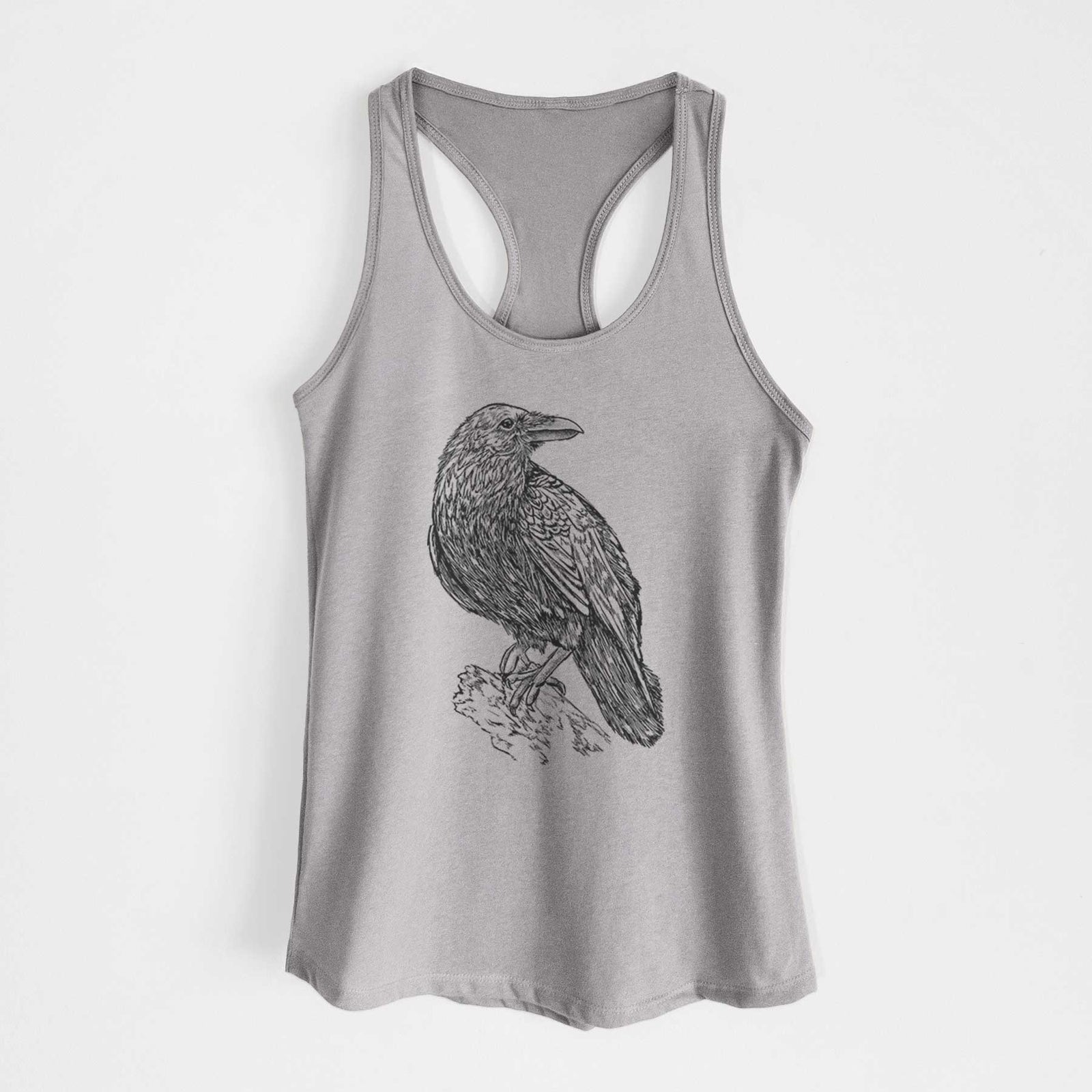 Heather grey women's racerback tank top laid flat, printed with a detailed black ink sketch of a common raven perched on a rock.
