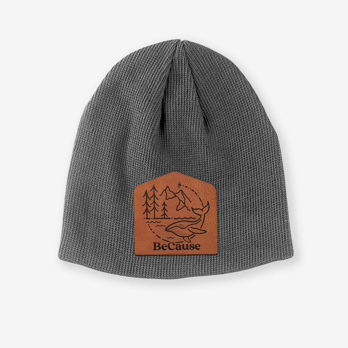 Grey cotton beanie with a black line art circle connecting a mountain range, pine trees, a bee and a whale swimming in ocean waves on the front.