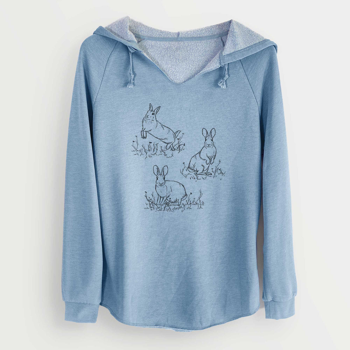 Misty blue women's Cali Wave hooded sweatshirt laid flat, printed with a black ink illustration of three cottontail rabbits among grass and flowers.