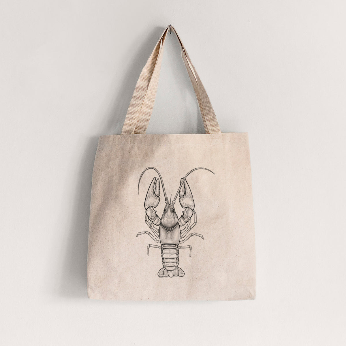 Natural canvas tote bag printed with a detailed black ink illustration of a crayfish with its claws raised, seen from above.