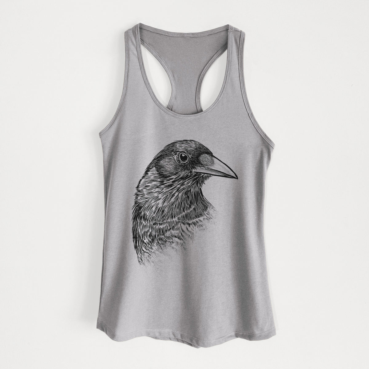 Heather grey women's racerback tank top laid flat, printed with a detailed black ink portrait of a crow's head in profile.