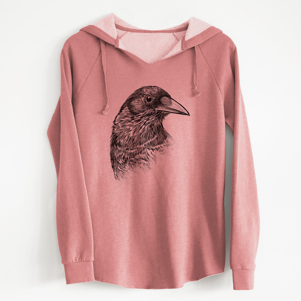 Dusty rose women's Cali Wave hooded sweatshirt laid flat, printed with a detailed black ink portrait of a crow's head in profile.