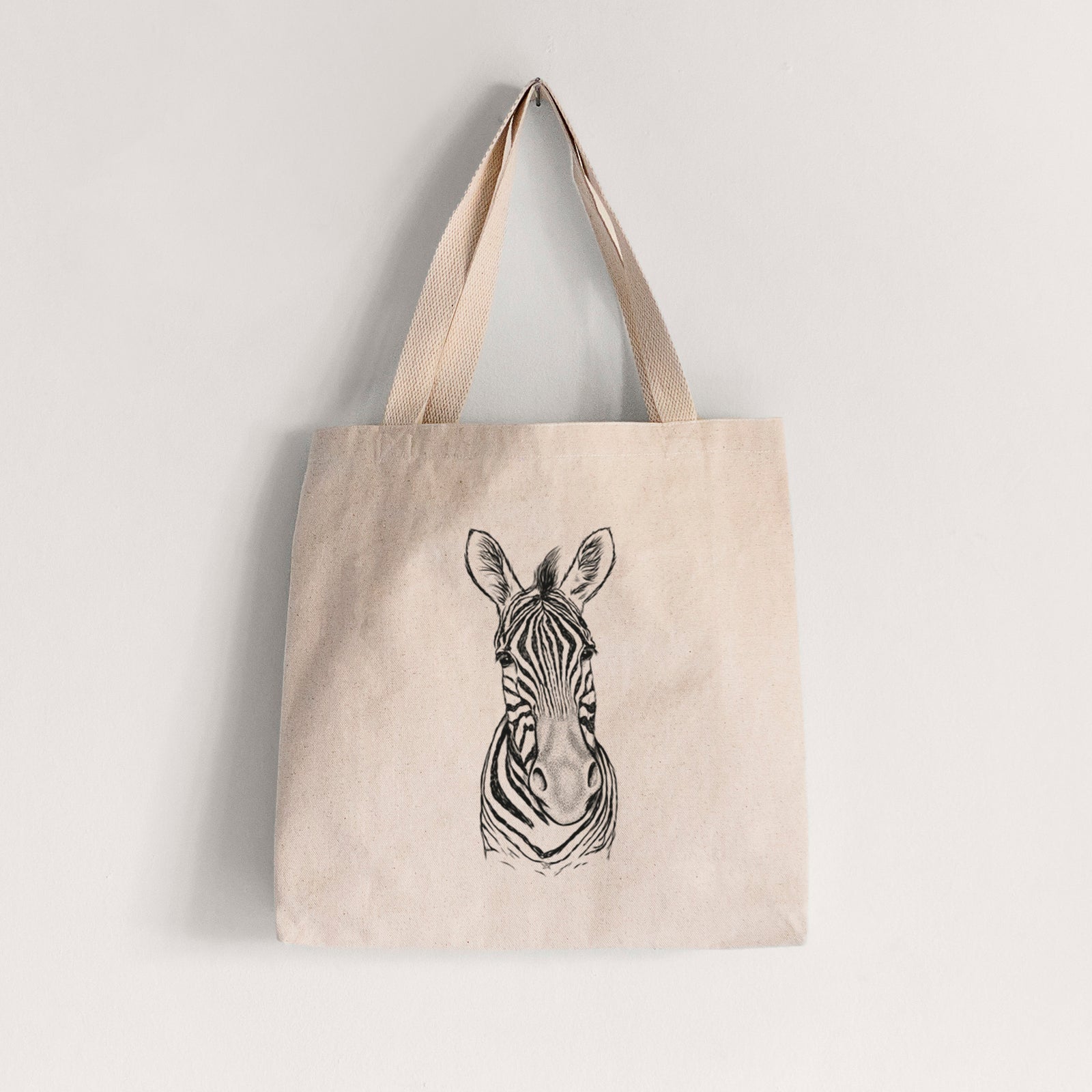 Natural canvas tote bag printed with a detailed black ink portrait of a Damara zebra facing forward.