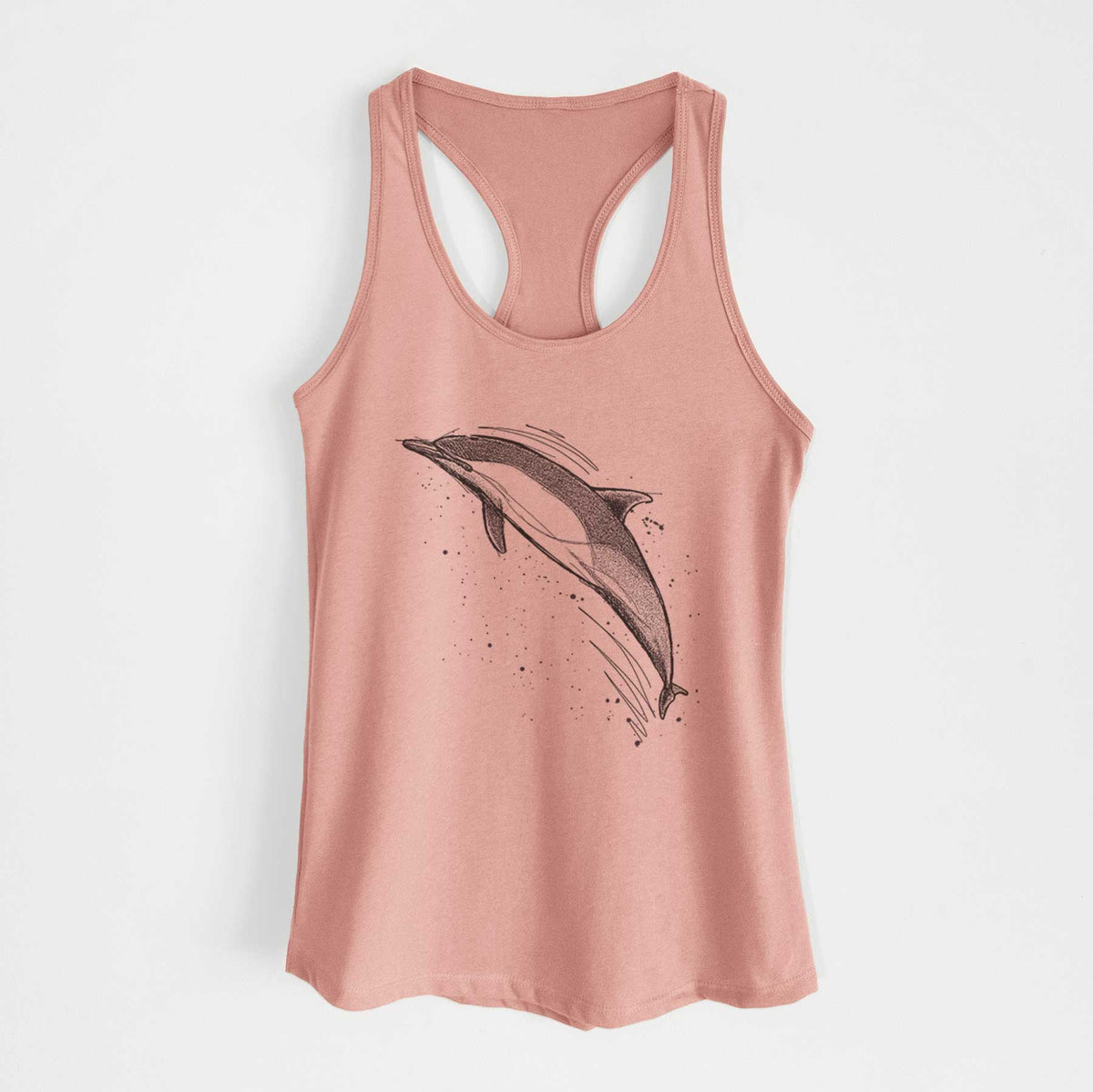 Desert pink women's racerback tank top laid flat, printed with a black ink illustration of a common dolphin leaping, with ink splatters.