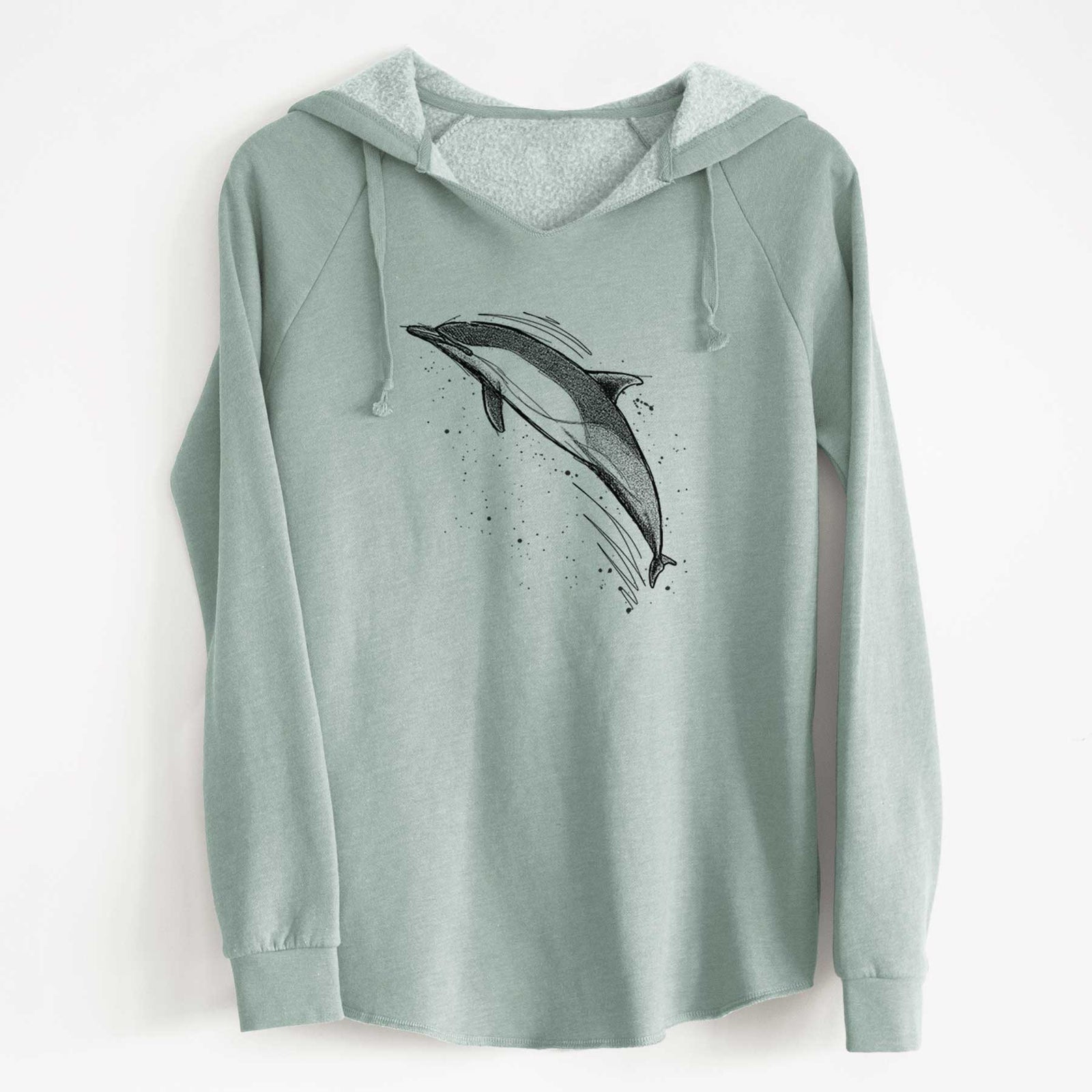 Sage green women's Cali Wave hooded sweatshirt laid flat, printed with a black ink illustration of a common dolphin leaping, with ink splatters.
