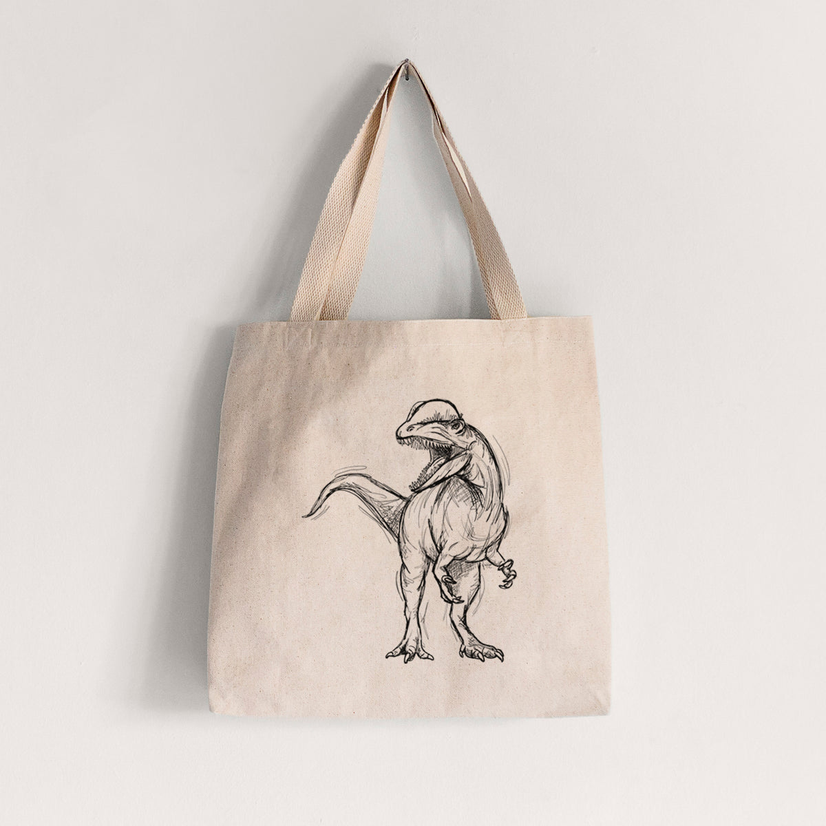 Natural canvas tote bag printed with a black ink illustration of a Dilophosaurus with its neck frill, walking.