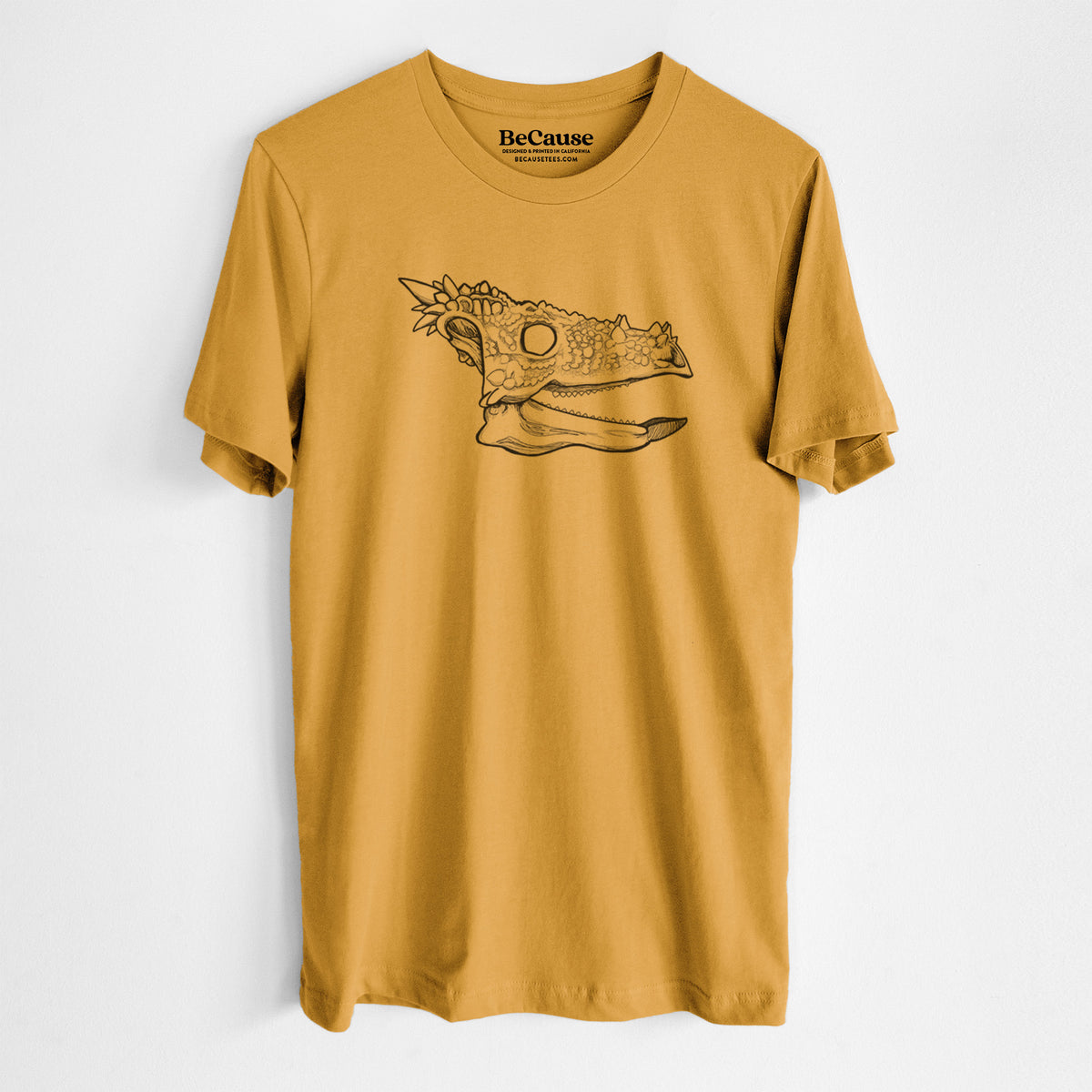 Mustard yellow lightweight cotton t-shirt laid flat, printed with a black ink illustration of a spiky Dracorex dinosaur skull.