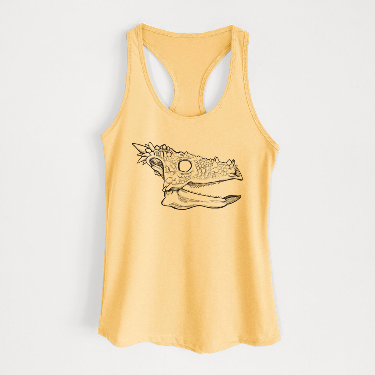 Banana cream women's racerback tank top laid flat, printed with a black ink illustration of a spiky Dracorex dinosaur skull.