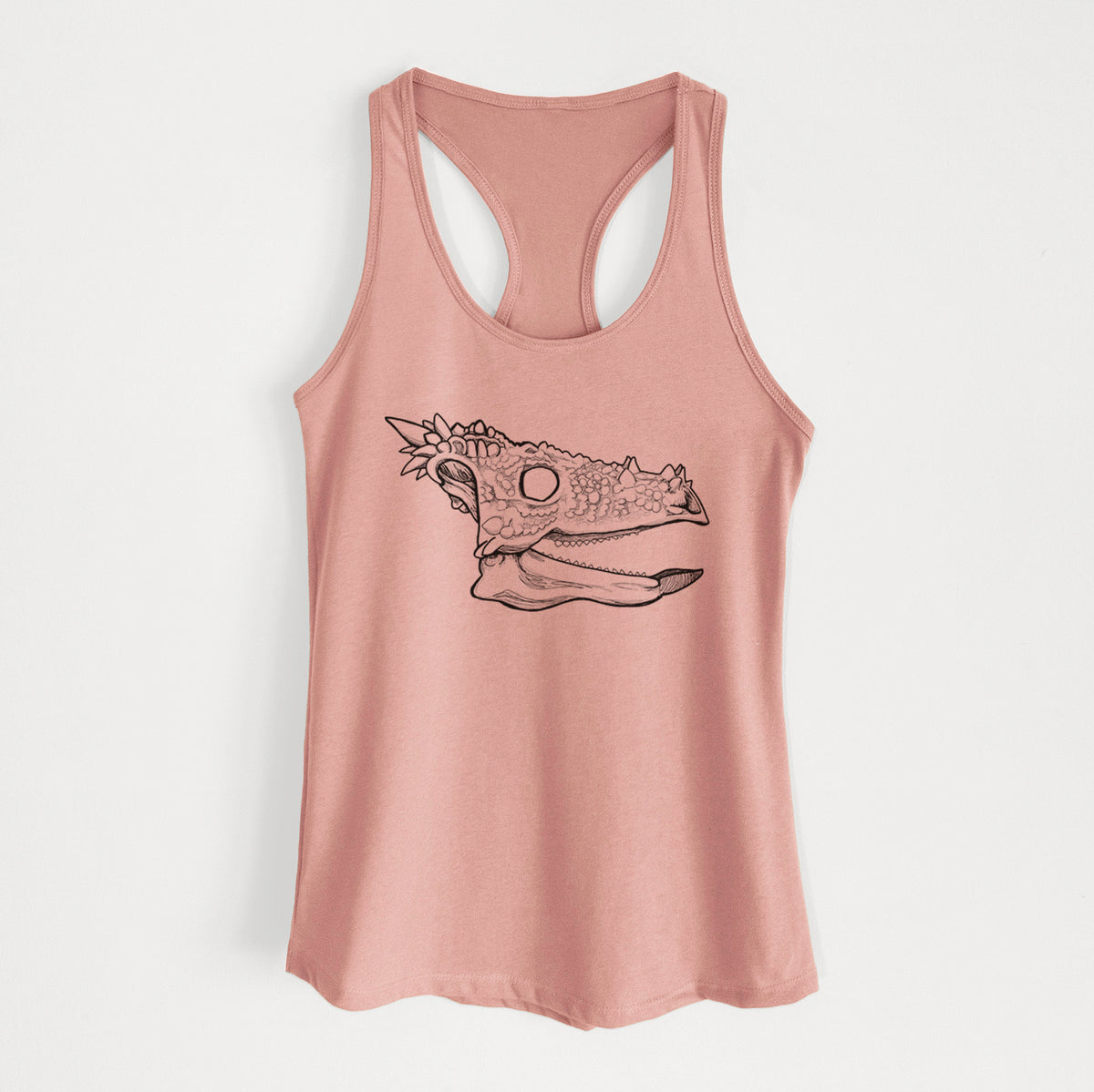 Desert pink women's racerback tank top laid flat, printed with a black ink illustration of a spiky Dracorex dinosaur skull.