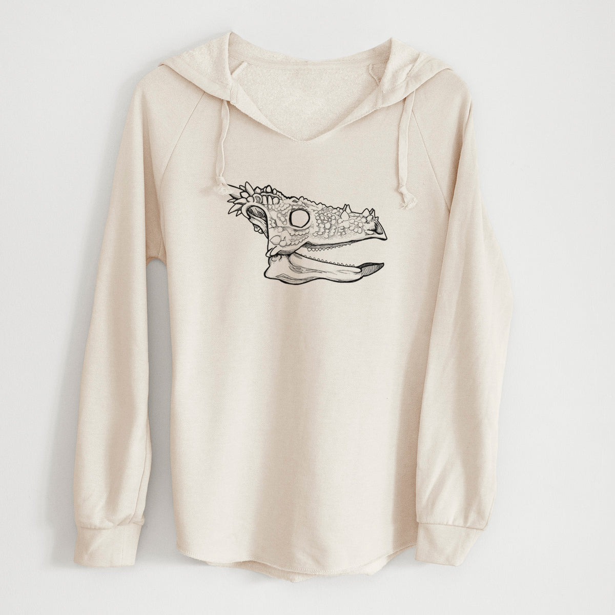 Bone cream women's Cali Wave hooded sweatshirt laid flat, printed with a black ink illustration of a spiky Dracorex dinosaur skull.