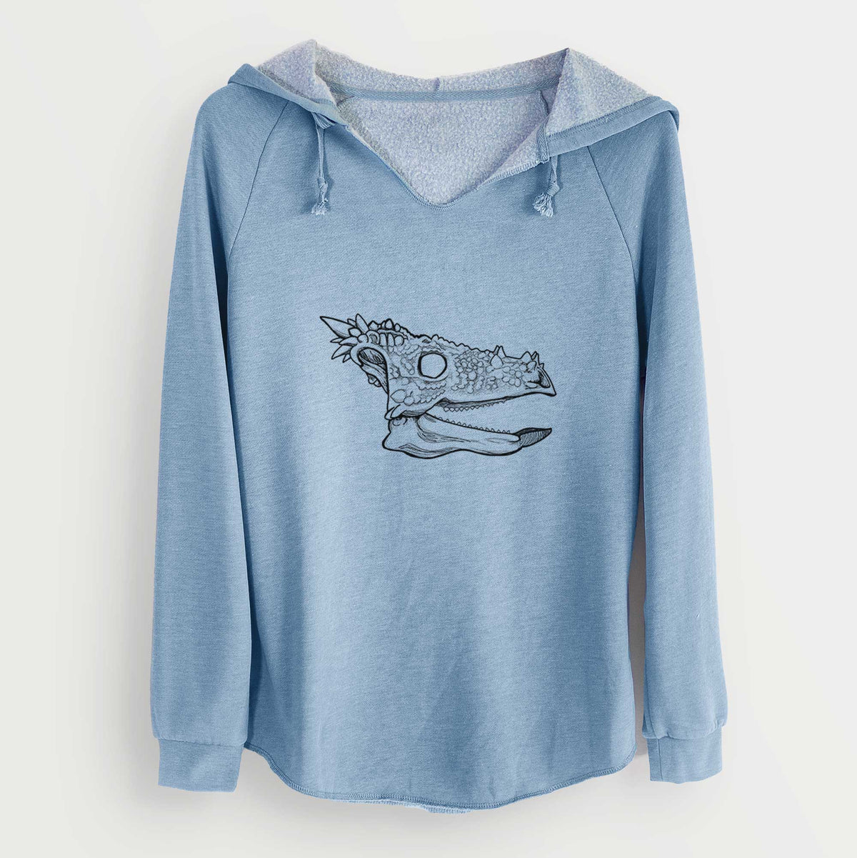Misty blue women's Cali Wave hooded sweatshirt laid flat, printed with a black ink illustration of a spiky Dracorex dinosaur skull.