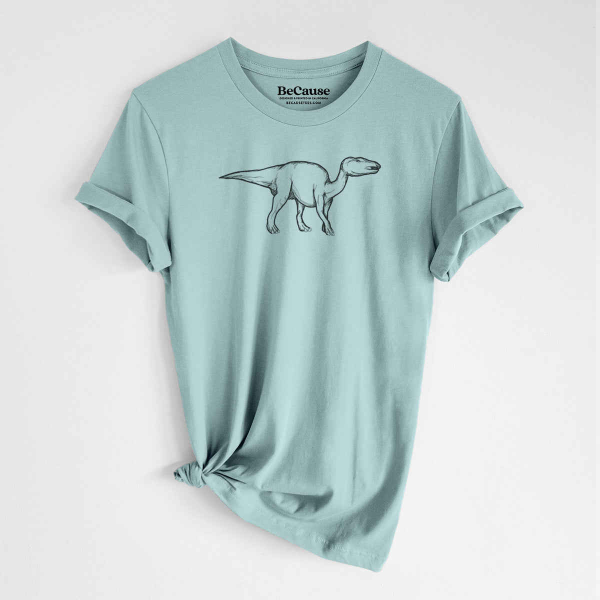 Dusty blue lightweight cotton t-shirt laid flat with the sleeves rolled, printed with a black ink illustration of an Edmontosaurus walking.
