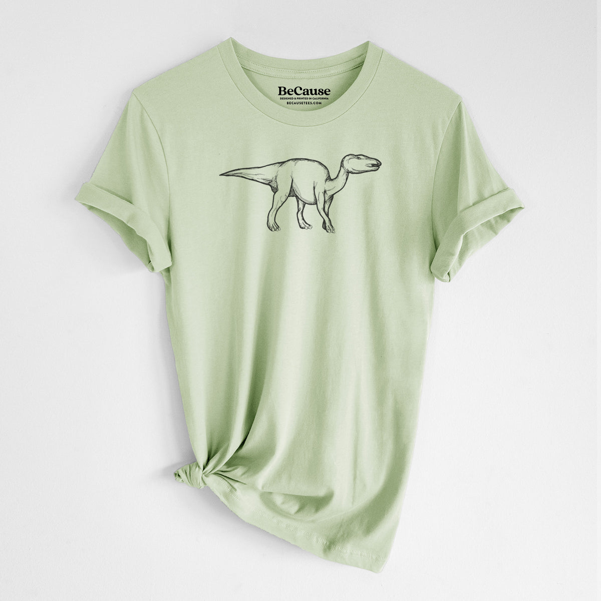 Spring green lightweight cotton t-shirt laid flat with the sleeves rolled, printed with a black ink illustration of an Edmontosaurus walking.