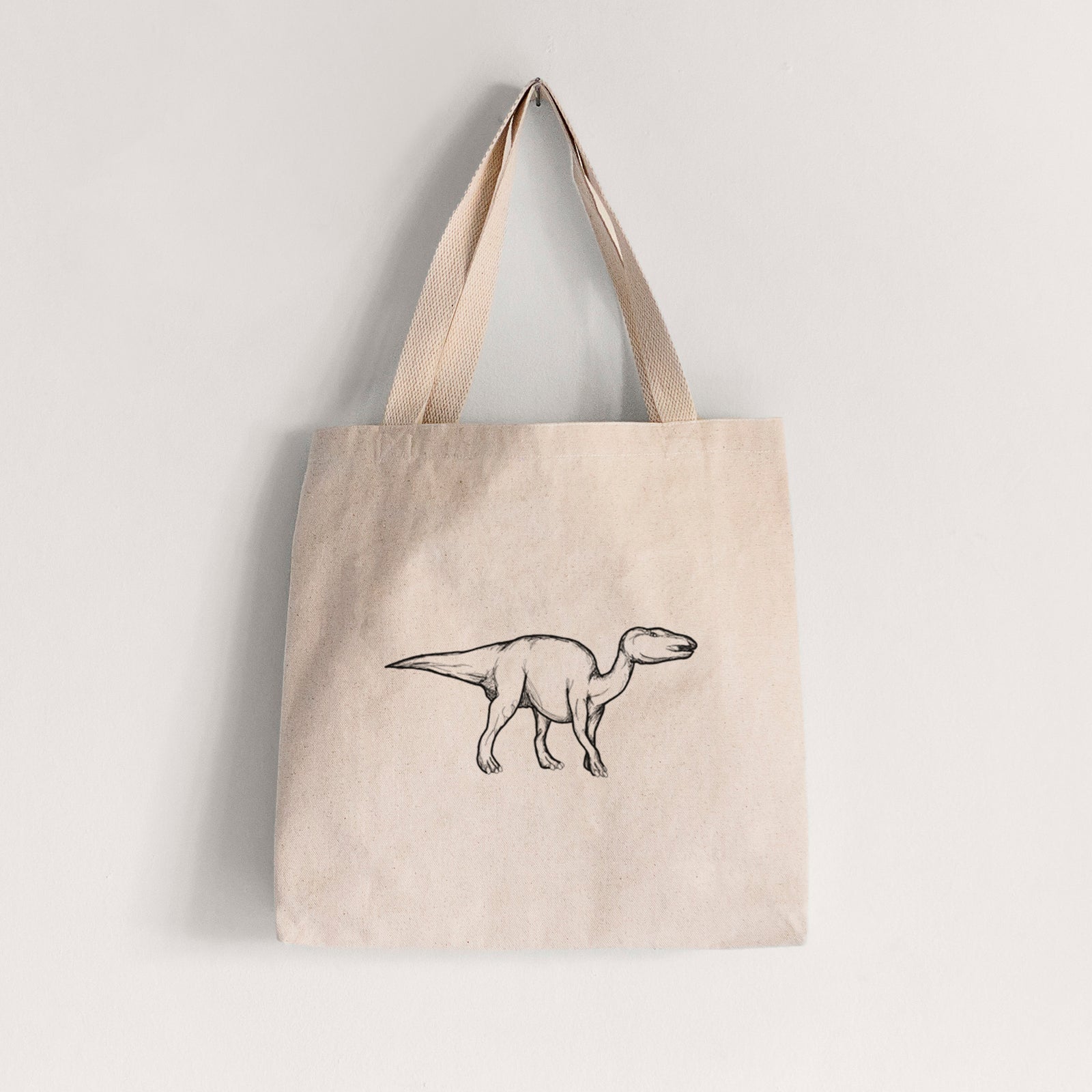 Natural canvas tote bag printed with a black ink illustration of an Edmontosaurus walking.