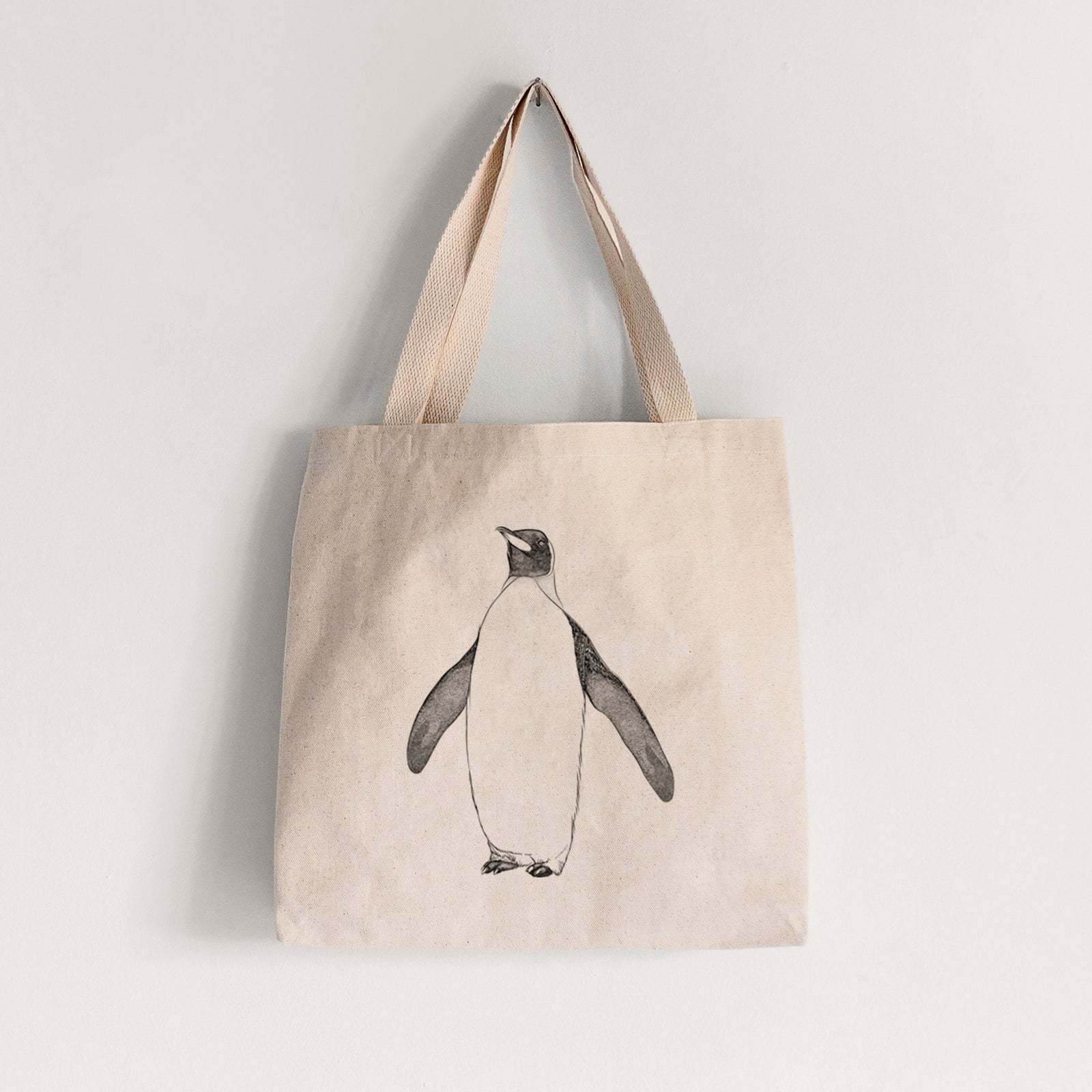 Natural canvas tote bag printed with a black ink illustration of an emperor penguin standing.