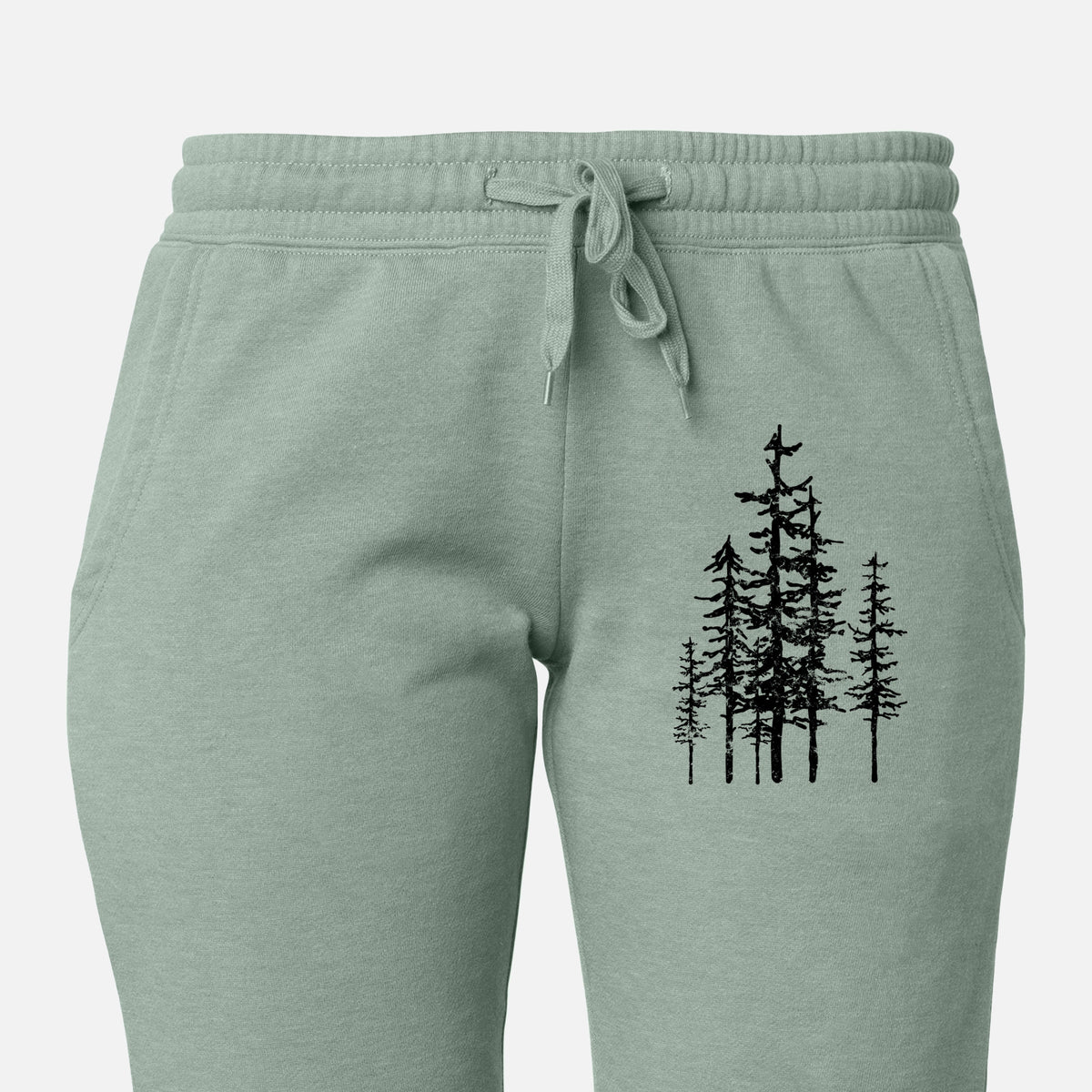Front of sage green Cali Wave sweatpants, printed with a black ink illustration of a cluster of evergreen trees of varying heights on the leg.