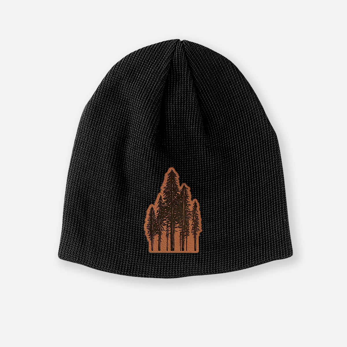 Black cotton beanie with a black ink illustration of a cluster of evergreen trees of varying heights on the front.