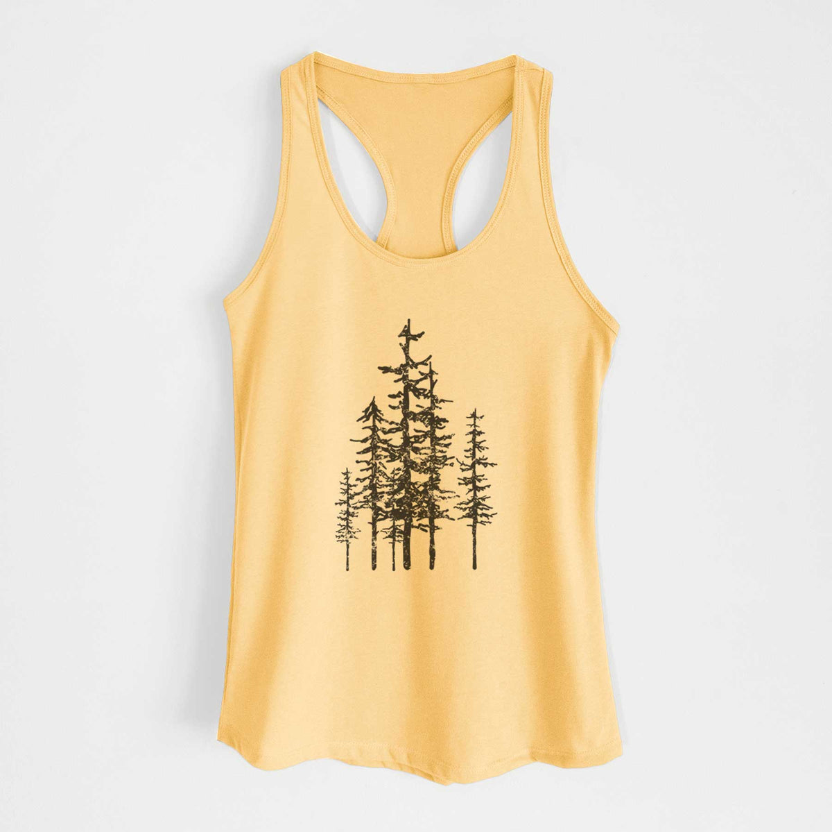 Banana cream women's racerback tank top laid flat, printed with a black ink illustration of a cluster of evergreen trees of varying heights.