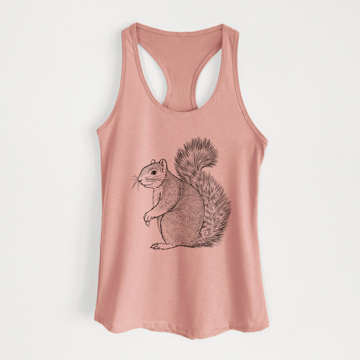 Desert pink women's racerback tank top laid flat, printed with a detailed black ink illustration of a fox squirrel sitting with a bushy tail.
