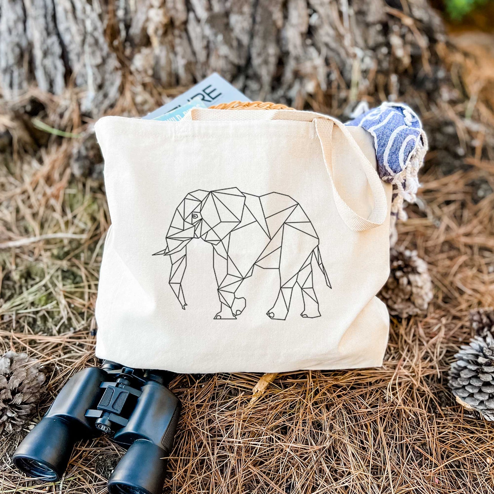 Natural canvas tote bag printed with a black geometric line art elephant.