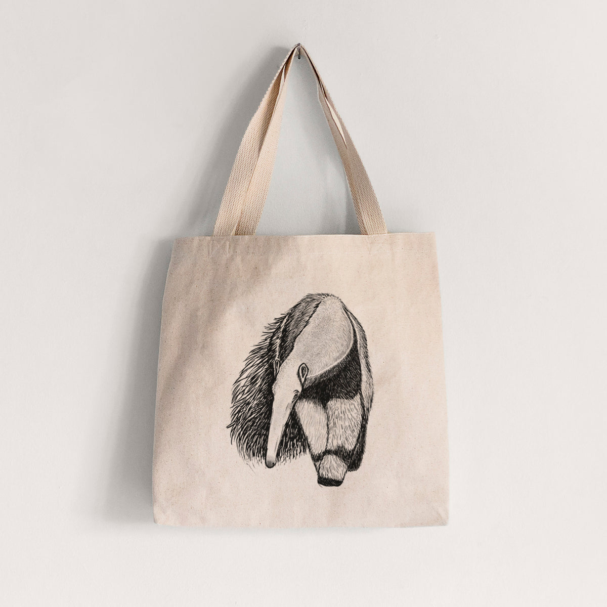 Natural canvas tote bag printed with a detailed black ink illustration of a giant anteater with its long snout and bushy tail.