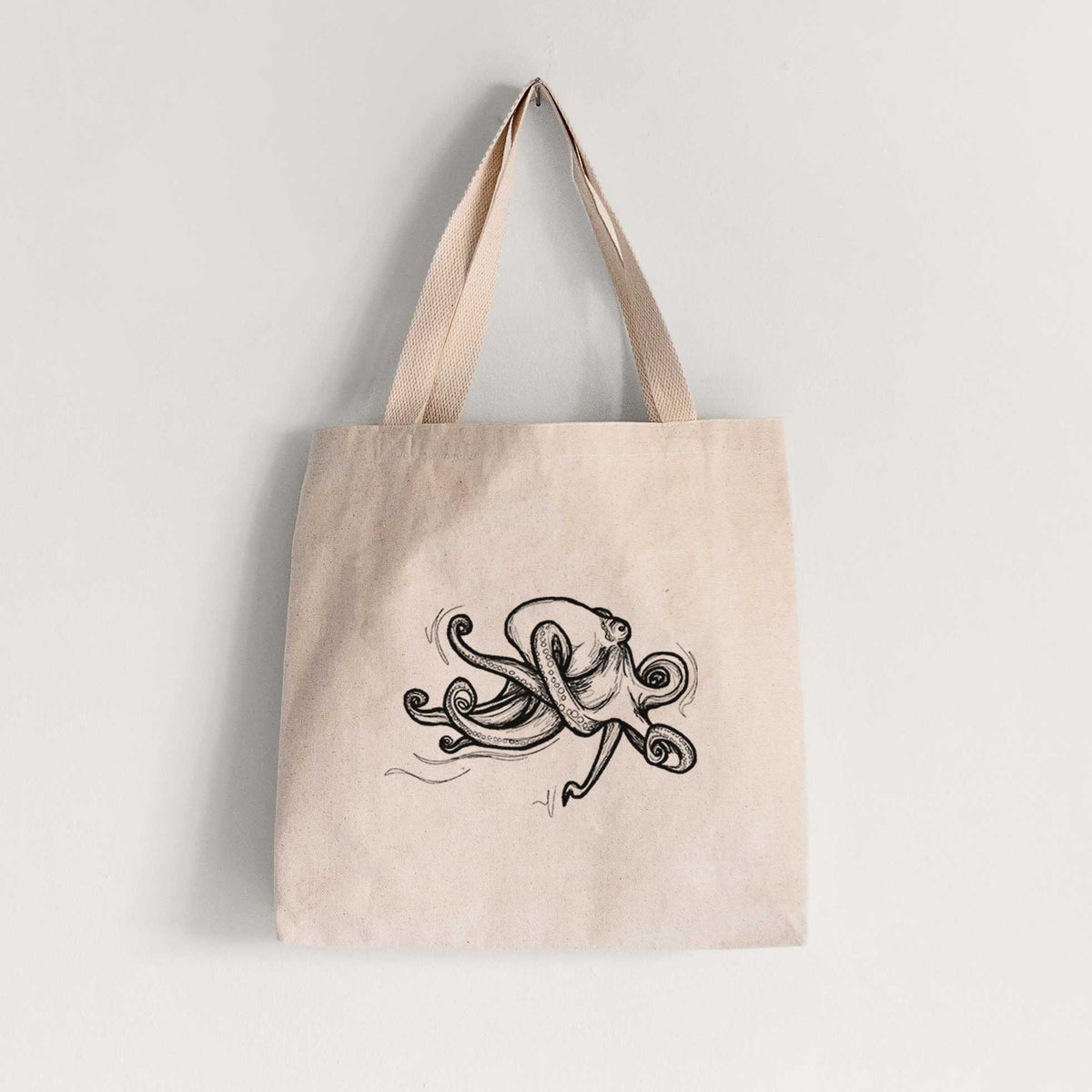 Natural canvas tote bag printed with a black ink illustration of a giant Pacific octopus with curling tentacles.