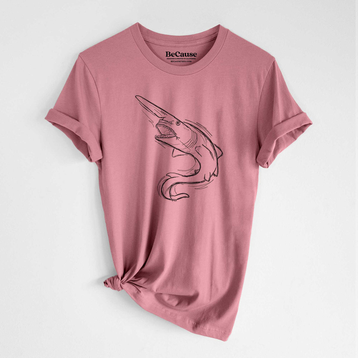 Mauve pink lightweight cotton t-shirt laid flat with the sleeves rolled, printed with a black ink illustration of a goblin shark with its long snout, swimming in a curve.