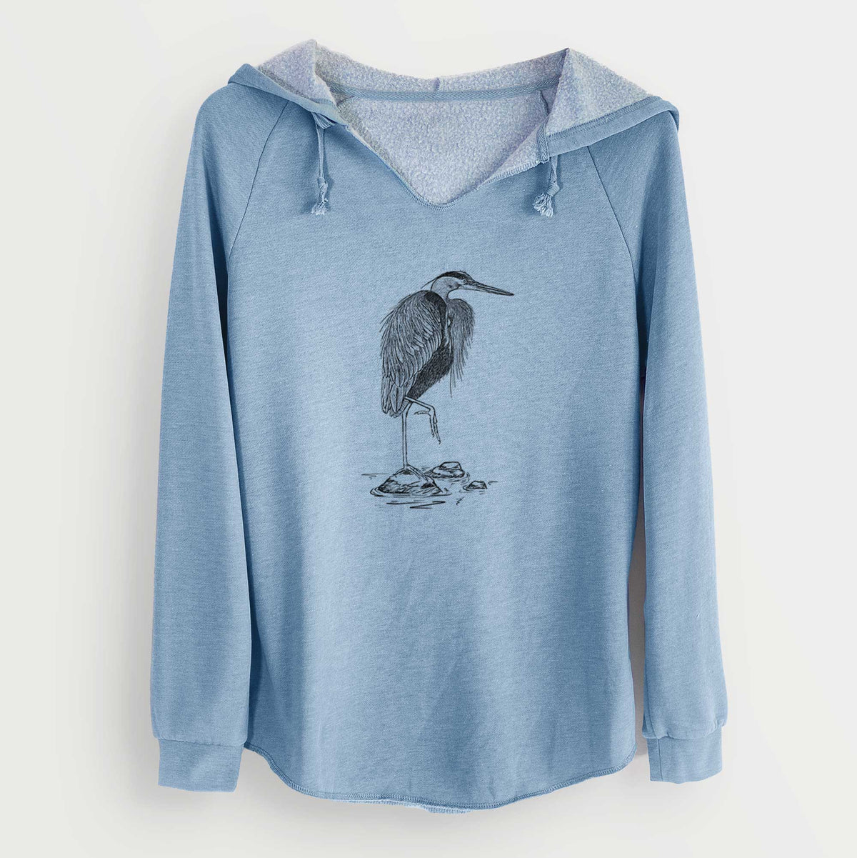 Misty blue women's Cali Wave hooded sweatshirt laid flat, printed with a detailed black ink illustration of a great blue heron standing on rocks.
