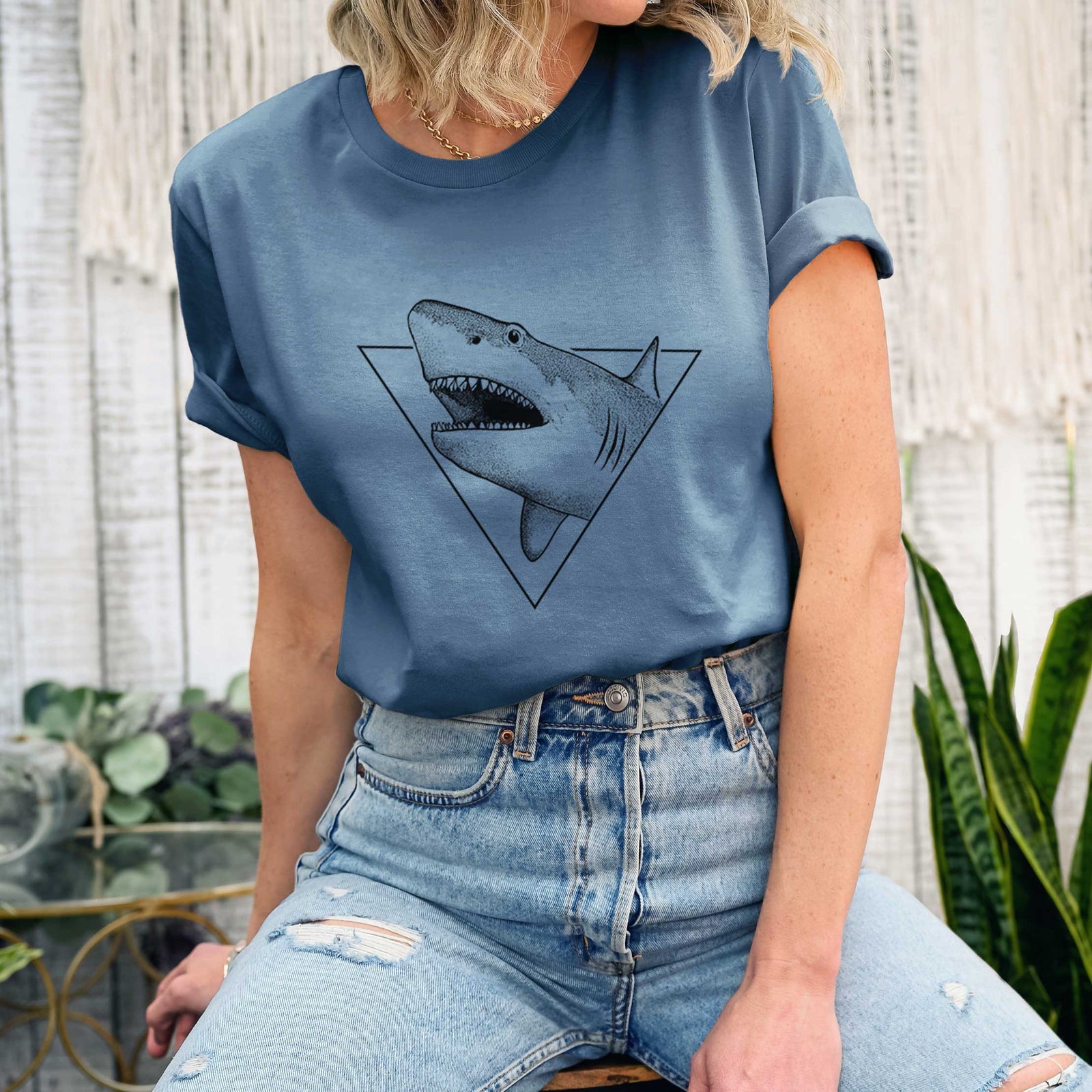 Leaf green lightweight cotton t-shirt laid flat, printed with a black ink great white shark bursting out of a triangle outline with its mouth open.