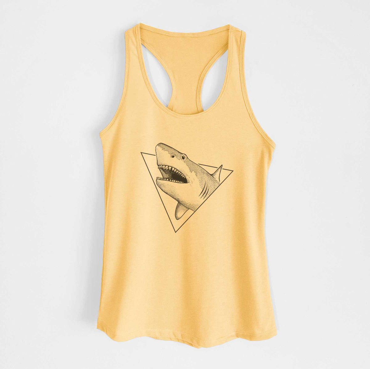 Banana cream women's racerback tank top laid flat, printed with a black ink great white shark bursting out of a triangle outline with its mouth open.