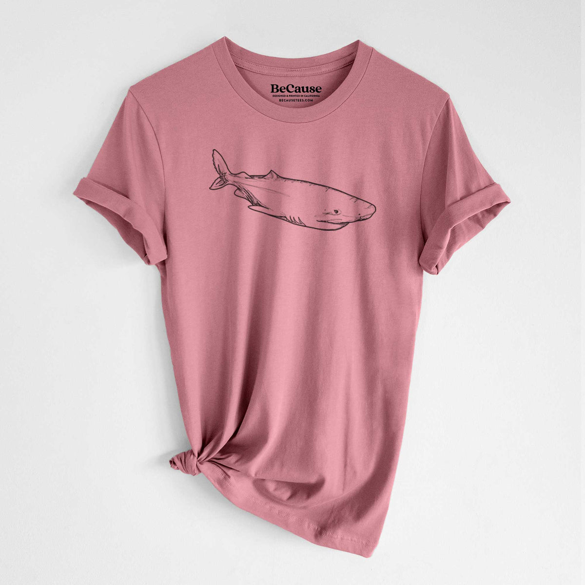 Mauve pink lightweight cotton t-shirt laid flat with the sleeves rolled, printed with a black ink illustration of a Greenland shark swimming.