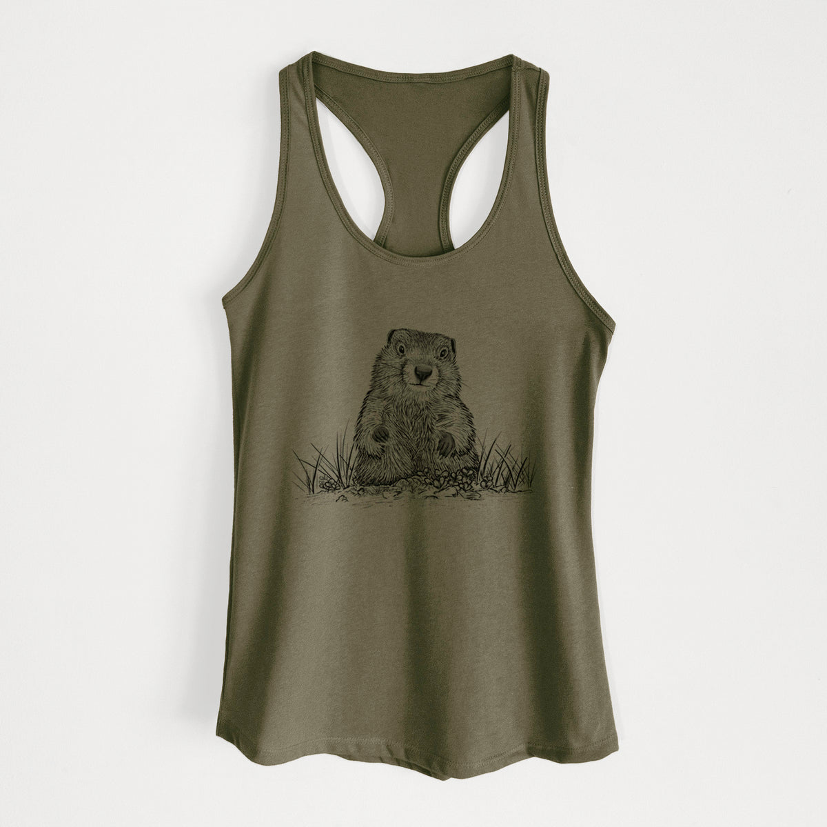 Military green women's racerback tank top laid flat, printed with a black ink illustration of a groundhog peeking out of its burrow among grass.