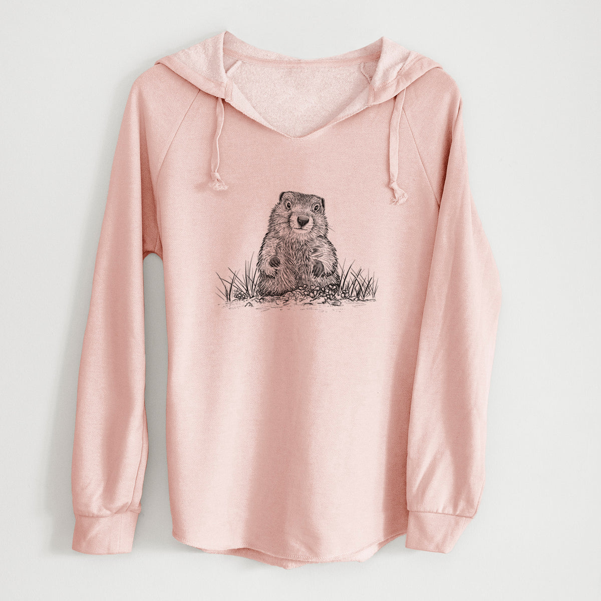 Blush pink women's Cali Wave hooded sweatshirt laid flat, printed with a black ink illustration of a groundhog peeking out of its burrow among grass.